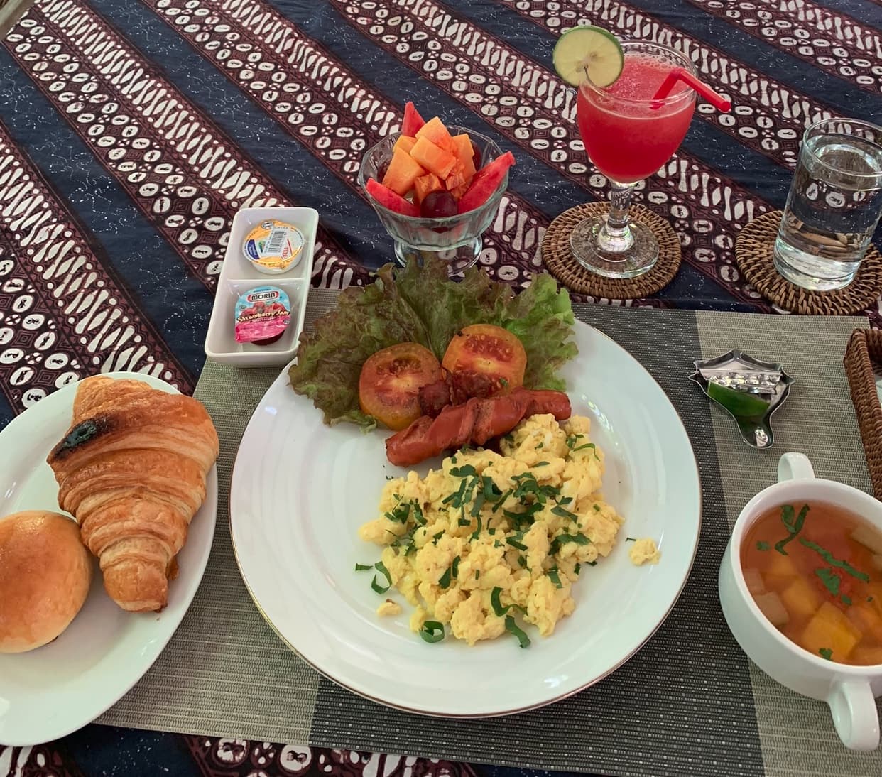 Фотография завтрака: выпечка, омлет, овощи, фрукты и сок.