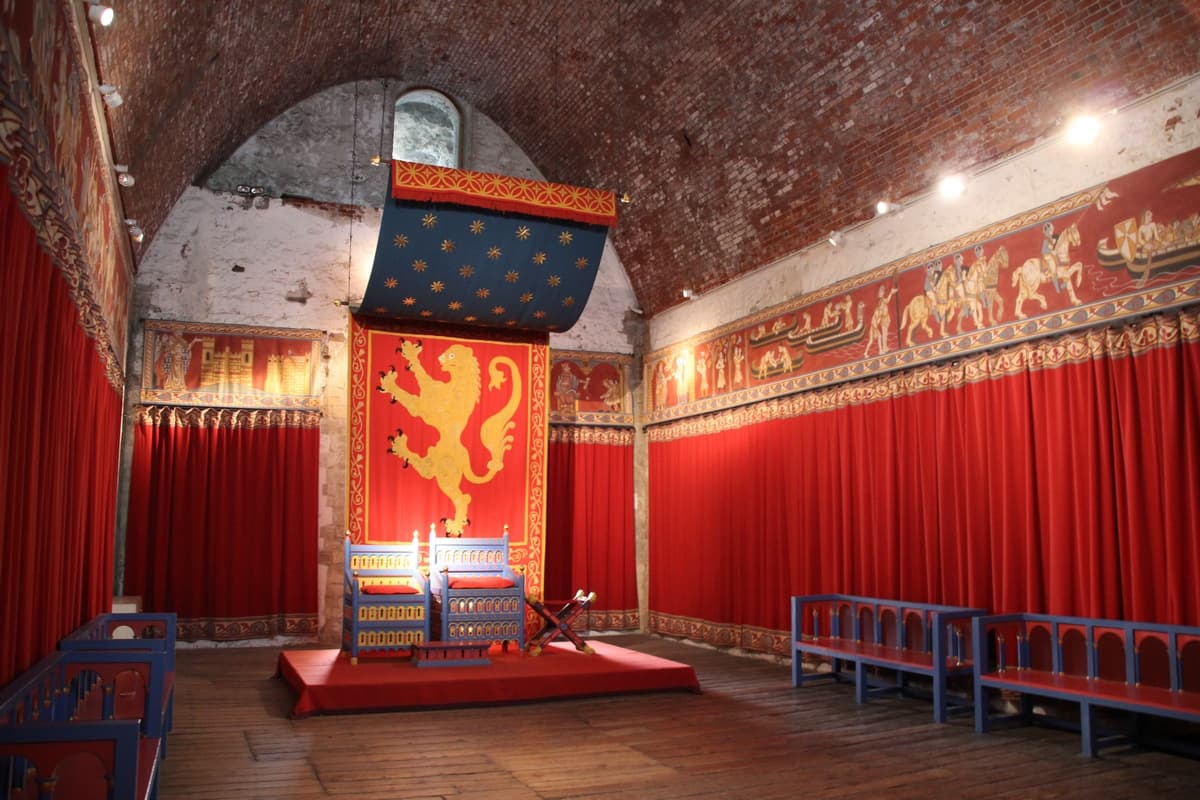 Тронный зал замка, оформленный в ярко красных тонах. Размер небольшой.